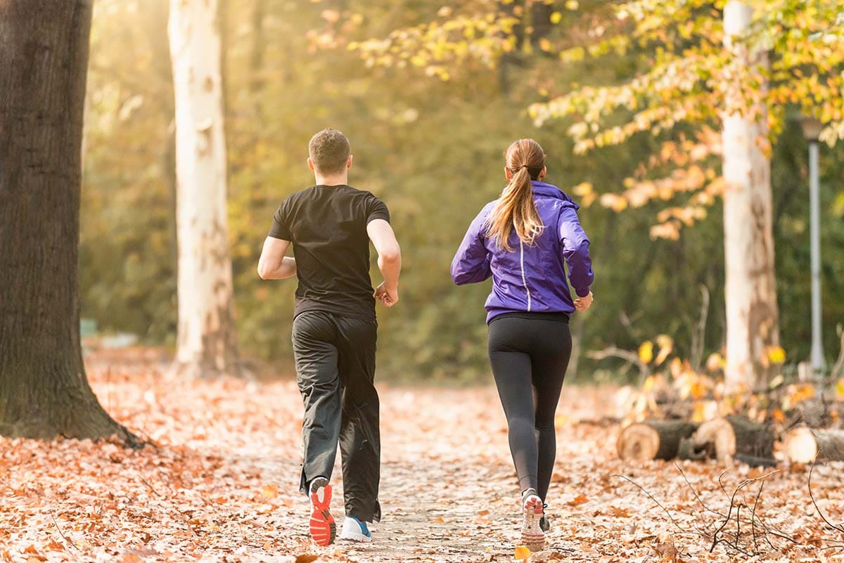 Man and woman jogging in woodland